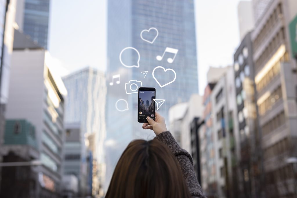 Manos sosteniendo un smartphone con el feed de Instagram, usado para ilustrar la obligación de marcar contenido regalado como publicidad.